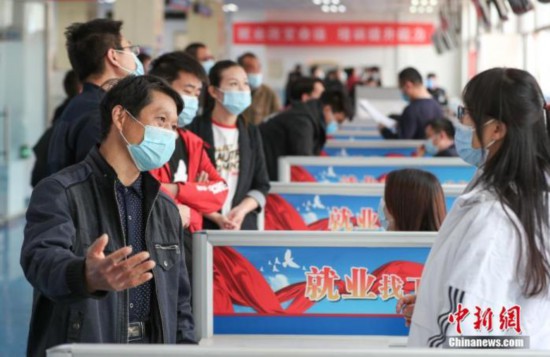 "4月2日，北京市顺义区人力资源市场内，求职者(左)向用工企业咨询。